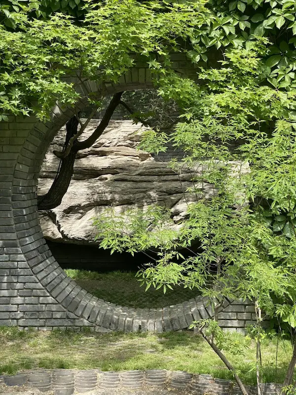 Perspective photo spot featuring three layers of blue brick moon gates by the pond at Beijing Red Brick Art Museum