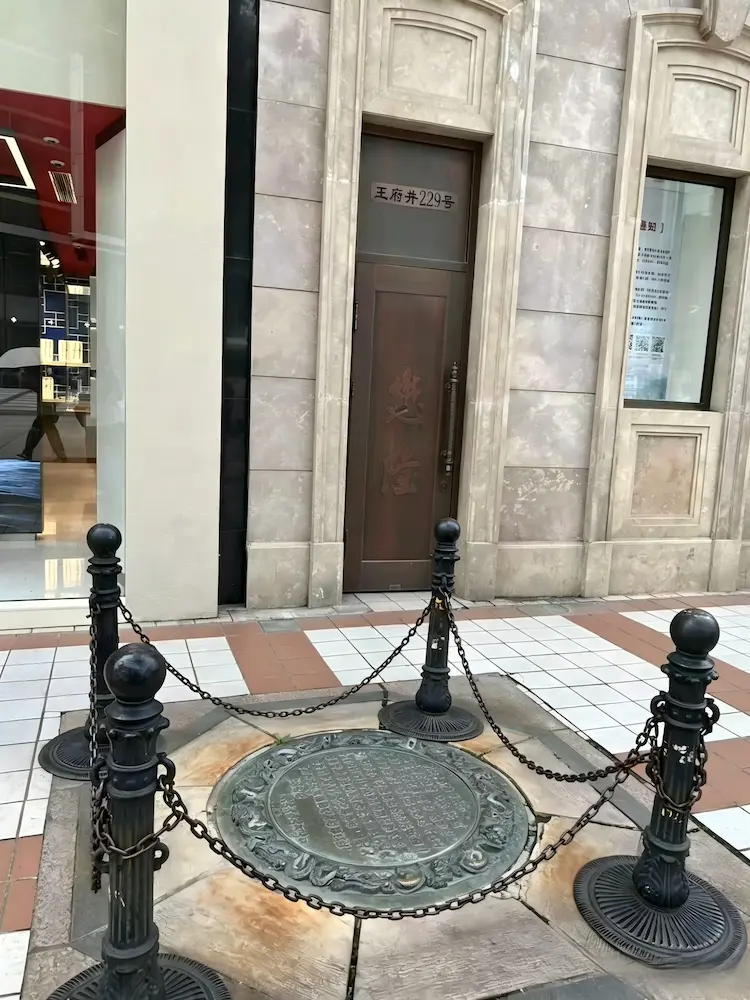 The ancient well in Wangfujing, with its well cover enclosed by iron chains