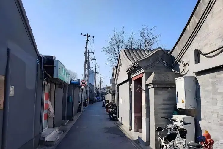 Gongmenkou Toutiao Hutong features grey walls and grey tiled rooftops.
