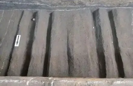 Dense ruts left by iron-wheeled carts on the stone slab